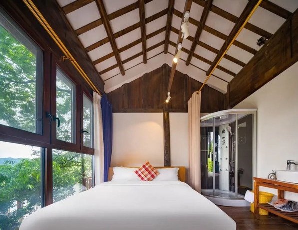 Imagen de la habitación del Hotel Zhangjiajie Ldyllic PondsideTimber Lodge. Foto 8