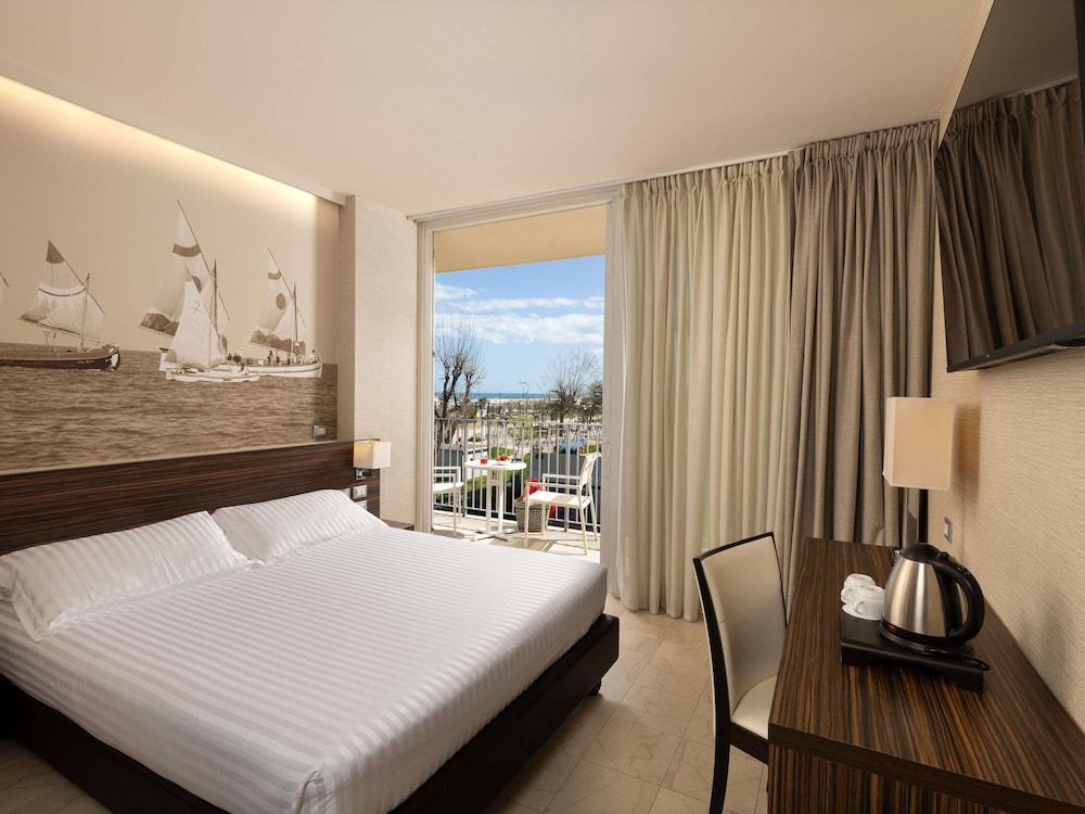 Habitación Clásica con cama matrimonial y bonito balcón del hotel Mercure Rimini Lungomare. Foto 1