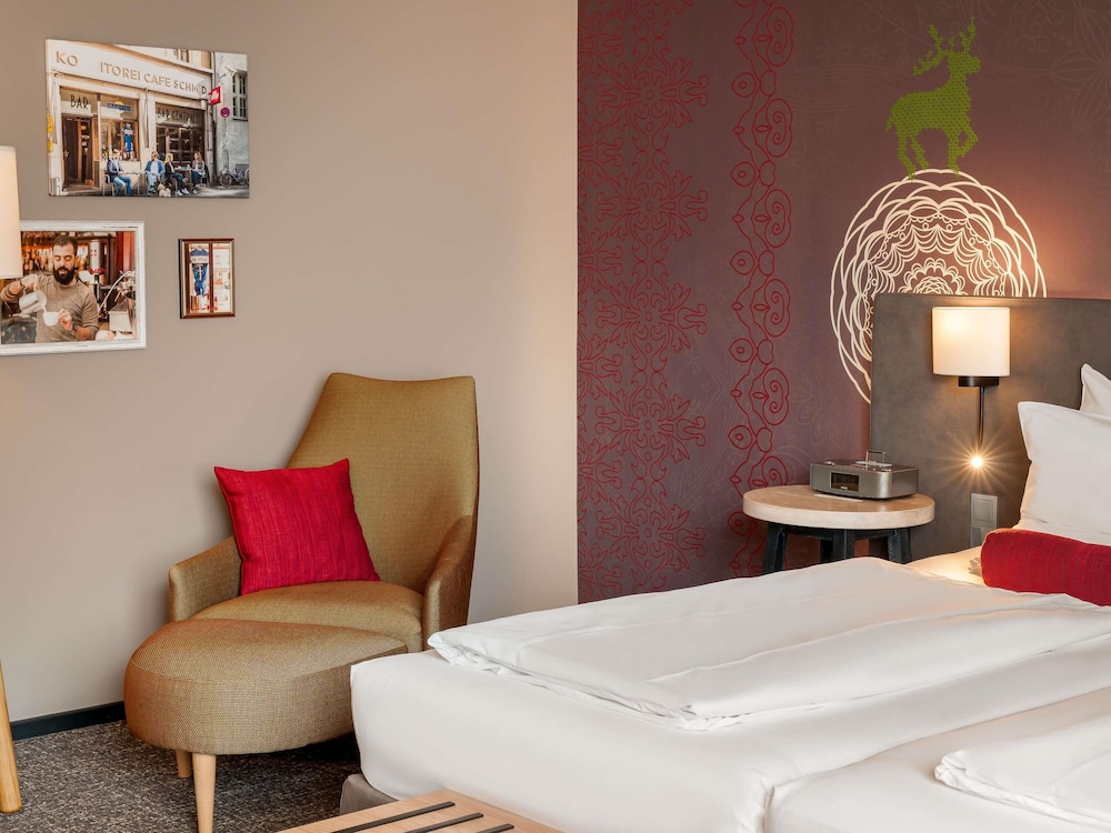 Habitación Superior con dos camas individuales y un sillón del hotel Mercure Muenchen City Center. Foto 1