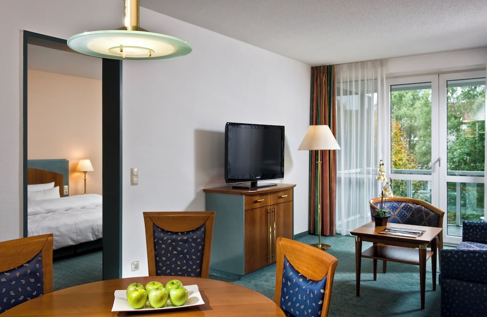 Suite con cama doble de 180 x 200 cm, salón independiente y balcón del hotel Congress Hotel Weimar by Mercure .