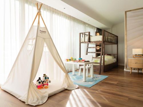 One - Bedroom Family Suite with One King Bed and Sofa Bed or Bunk Beds del hotel Mövenpick Bdms Wellness Resort Bangkok. Foto 3