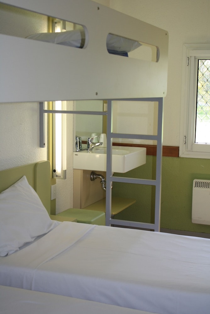 2 camas individuales y 1 cama individual del hotel Ibis Budget Canberra. Foto 3