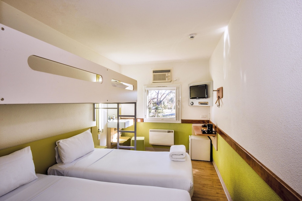 2 camas individuales y 1 cama individual del hotel Ibis Budget Canberra. Foto 4