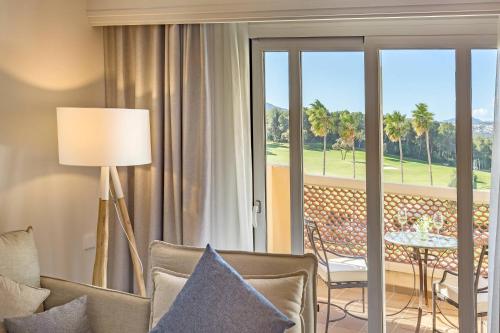 Suite con cama extragrande, sofá cama, balcón y vistas al complejo del hotel Denia la Sella Golf Resort and Spa. Foto 7
