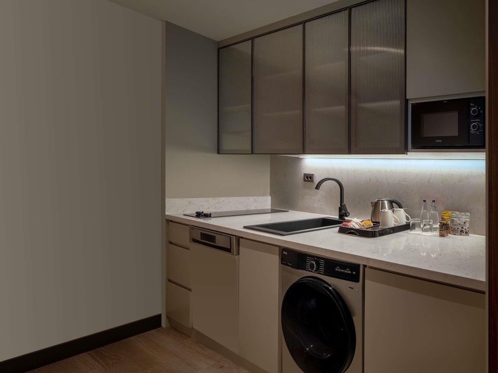 Habitación Superior con 2 camas individuales, sofá y cocina americana del hotel Mercure Istanbul Altunizade. Foto 3