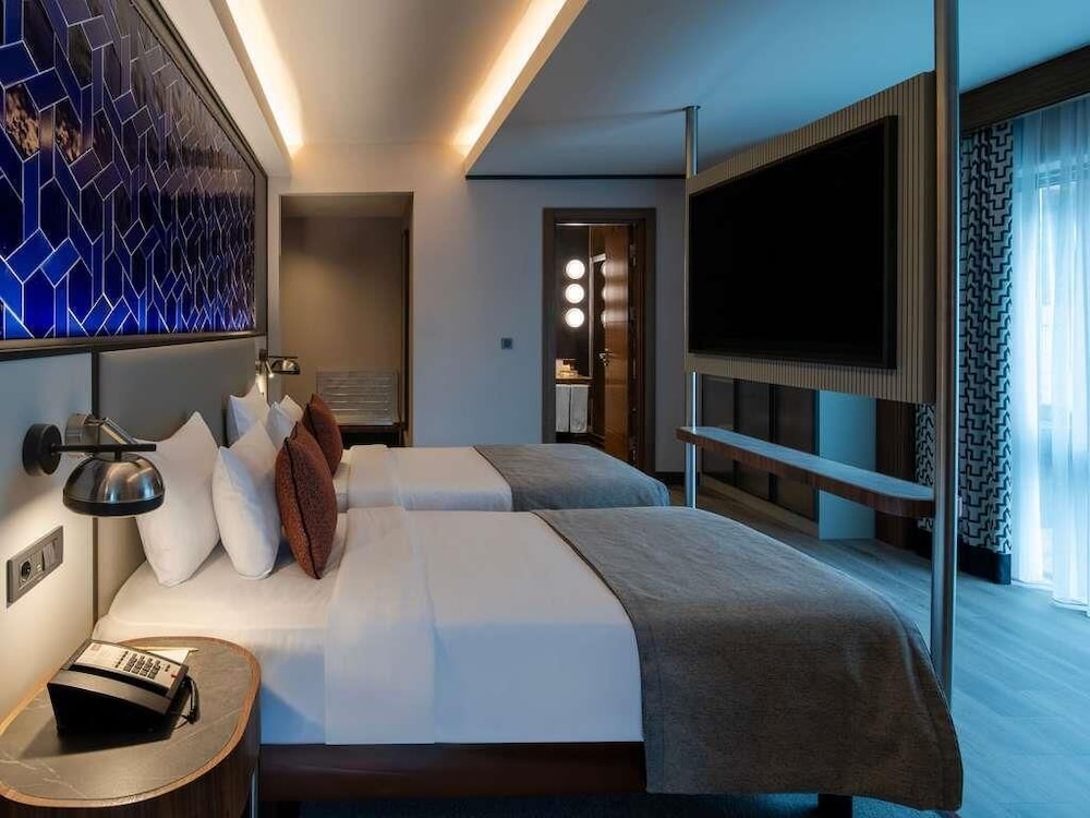 Habitación Superior con 2 camas individuales, sofá y cocina americana del hotel Mercure Istanbul Altunizade. Foto 4