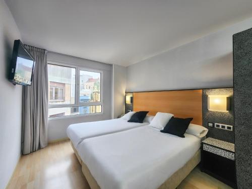2 camas individuales y sofá del hotel Faranda Pathos Gijón, Ascend Hotel Collection