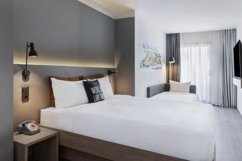 Habitación Moxy Doble con sofá cama y balcón del hotel Moxy Barcelona