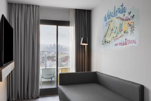 Habitación Moxy Doble con sofá cama y balcón del hotel Moxy Barcelona. Foto 1