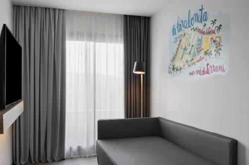Habitación Moxy Doble con sofá cama y balcón del hotel Moxy Barcelona. Foto 7