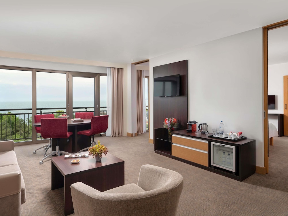 Suite con una cama doble y sofá del hotel Novotel Trabzon. Foto 3