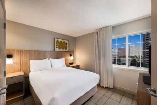 Estudio con cama extragrande y vistas parciales al puerto del hotel Sonesta Simply Suites Jersey City. Foto 1