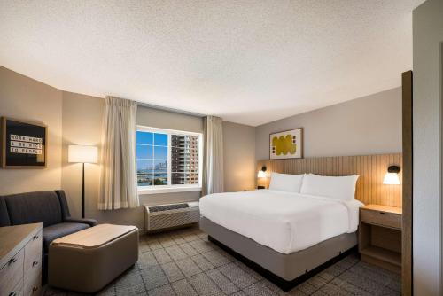 Estudio con cama extragrande y vistas parciales al puerto del hotel Sonesta Simply Suites Jersey City. Foto 5