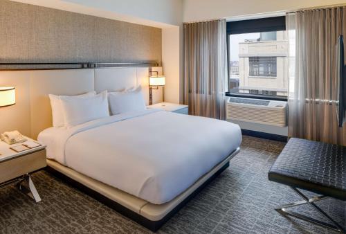 Suite Junior con cama extragrande y zona de estar del hotel Doubletree Jersey City. Foto 5