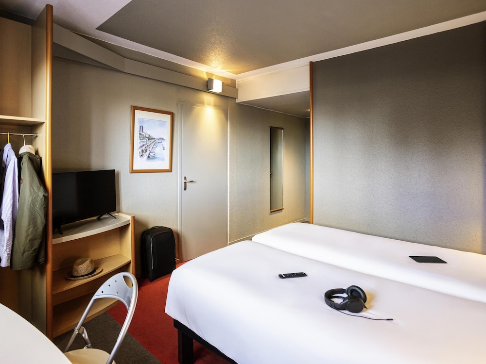 Habitación con dos camas individuales equipada con nueva ropa de cama del hotel Ibis Tarbes Odos. Foto 1