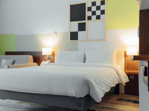 Habitación estándar con una cama doble y sofá del hotel Ibis Styles Warsaw Airport. Foto 5