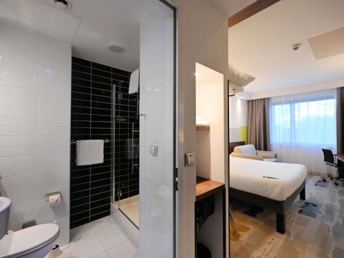 Habitación estándar con una cama doble y sofá del hotel Ibis Styles Warsaw Airport. Foto 7