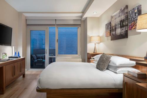 Habitación con cama extragrande y balcón del hotel The Gotham Hotel. Foto 2