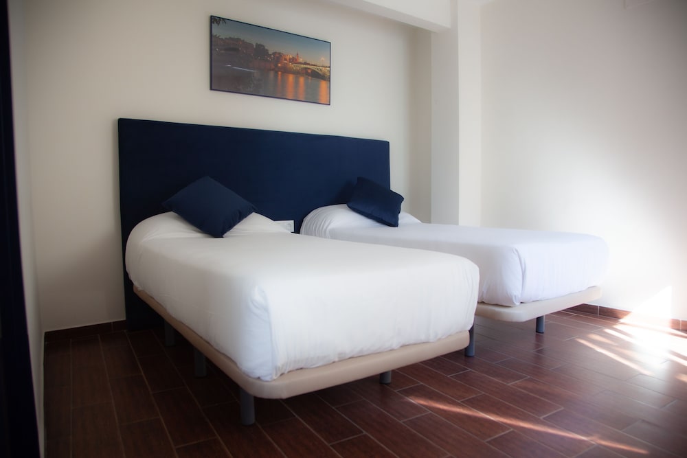 Habitación con 2 camas individuales del hotel Noches En Triana. Foto 1