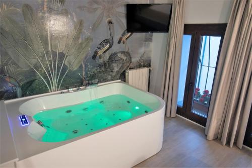 Habitación con cama grande y bañera de hidromasaje del hotel Vitium Córdoba. Foto 1