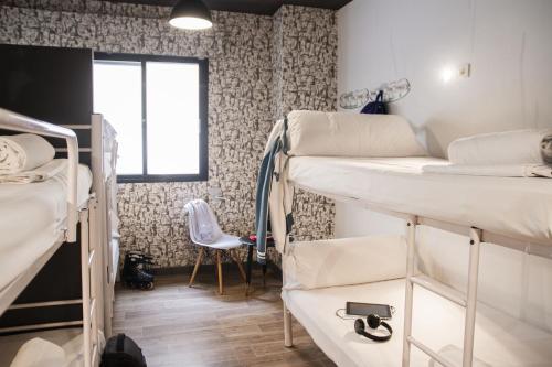 Cama Individual en una habitación compartida para mujeres con 8 camas y baño privado  del hotel Room00 Ventura. Foto 4
