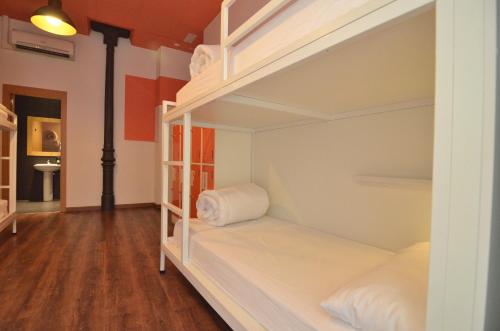 Cama en habitación compartida mixta con 8 camas y baño del hotel Far Home Atocha. Foto 3