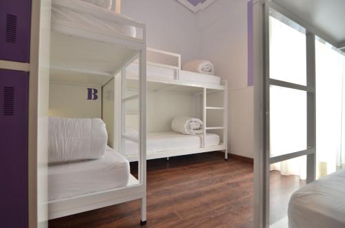 Cama en habitación compartida femenina con 6 camas y baño del hotel Far Home Atocha. Foto 5
