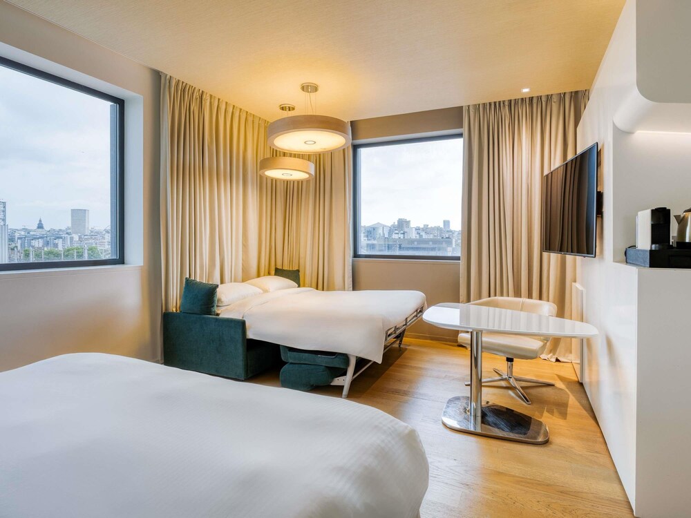 Habitación familiar, 1 cama de matrimonio grande con sofá cama, vistas a la ciudad del hotel Pullman Brussels Centre Midi. Foto 1