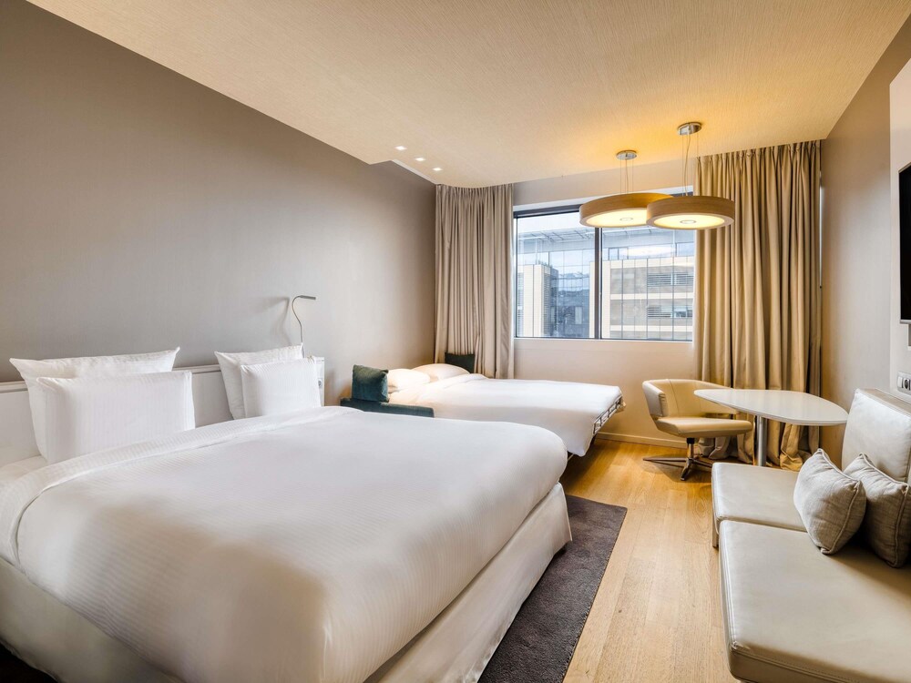 Habitación familiar, 1 cama de matrimonio grande con sofá cama, vistas a la ciudad del hotel Pullman Brussels Centre Midi. Foto 3