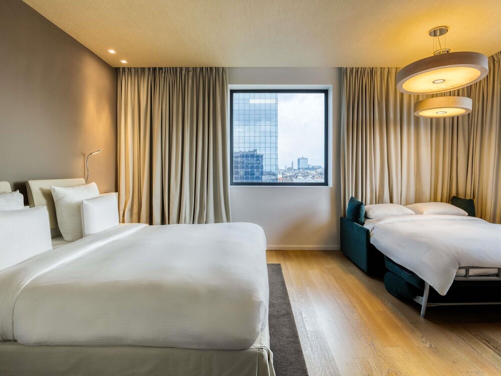 Habitación familiar, 1 cama de matrimonio grande con sofá cama, vistas a la ciudad del hotel Pullman Brussels Centre Midi. Foto 6
