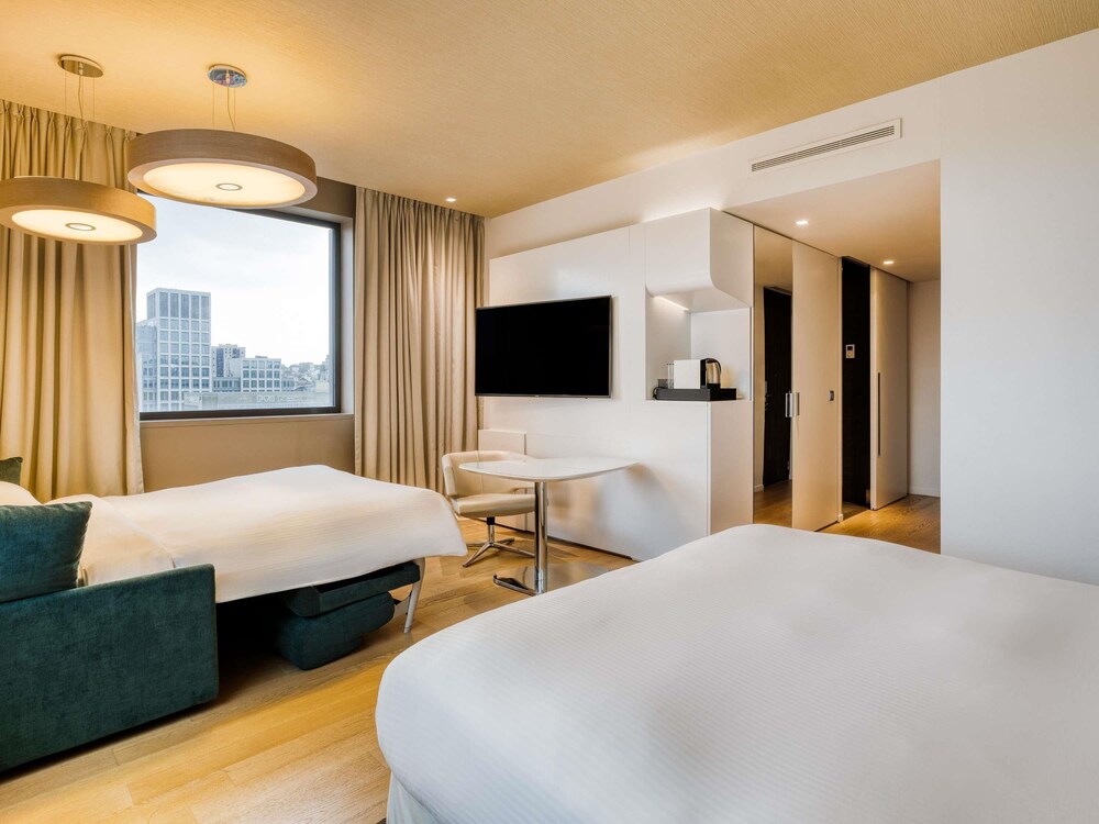 Habitación familiar, 1 cama de matrimonio grande con sofá cama, vistas a la ciudad del hotel Pullman Brussels Centre Midi. Foto 7