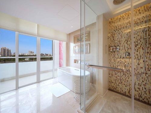 Suite Deluxe con vistas al mar y balcón - Cama extragrande del hotel Pullman Haikou. Foto 2