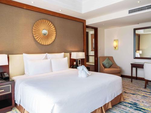 Suite Deluxe con vistas al mar y balcón - Cama extragrande del hotel Pullman Haikou. Foto 5