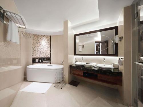 Suite Deluxe con vistas al mar y balcón - Cama extragrande del hotel Pullman Haikou. Foto 6