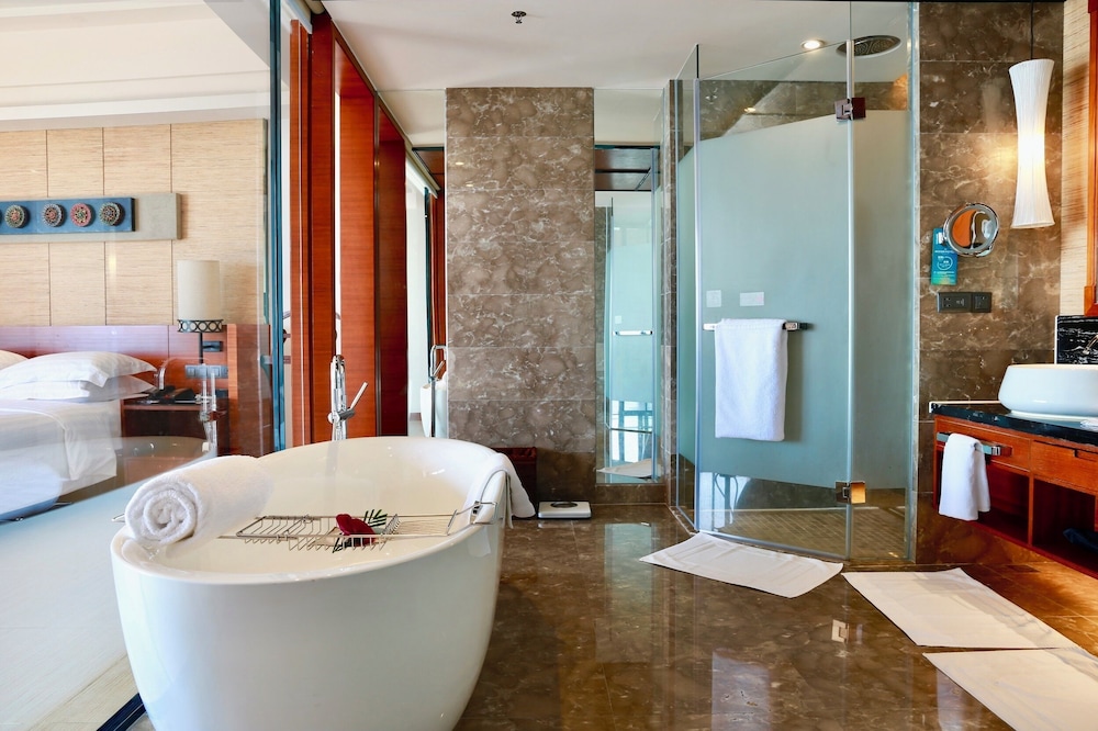 Suite Ejecutiva con una cama king - size y sala de estar. Disfrute de las vistas al océano del hotel Pullman Oceanview Sanya Bay Resort and Spa. Foto 5