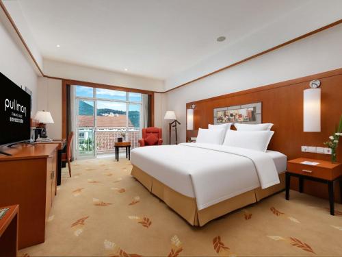 Habitación Executive Deluxe con cama extragrande y acceso al salón del hotel Pullman Zhangjiajie. Foto 1