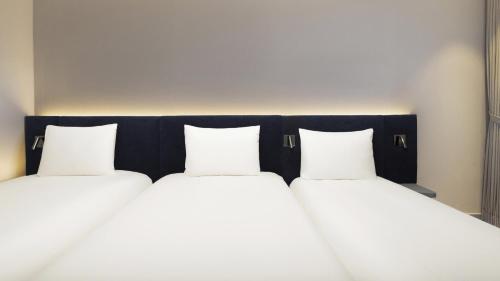 Habitación Triple Premium con 3 camas individuales del hotel Ibis Ambassador Seoul Insadong. Foto 1