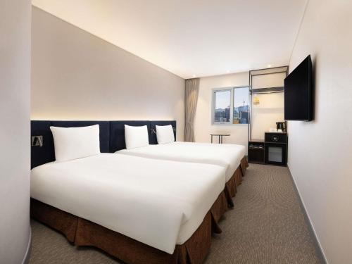 Habitación Triple Superior con 3 camas individuales del hotel Ibis Ambassador Seoul Insadong. Foto 3