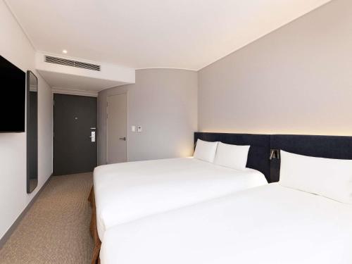Habitación Triple Superior con 3 camas individuales del hotel Ibis Ambassador Seoul Insadong. Foto 8