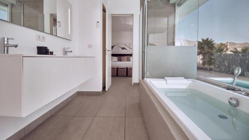 Suite Divinity Mar de 1 dormitorio con piscina privada, bañera de hidromasaje y vistas al mar del hotel Baobab Suites