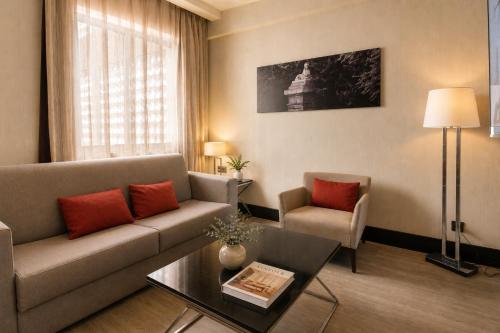 Habitación Executive con zona de salón y cama grande del hotel Novotel Madrid Center. Foto 1