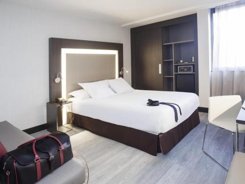 Habitación Estándar con cama grande y sofá del hotel Novotel Madrid Center. Foto 3