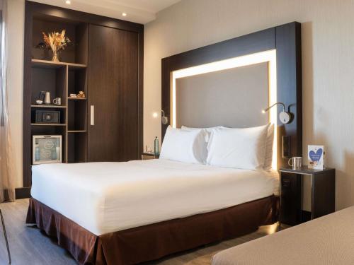 Habitación Estándar con cama grande y sofá del hotel Novotel Madrid Center. Foto 11