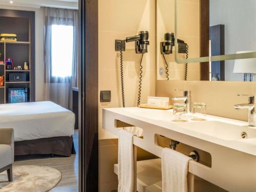 Habitación Executive con zona de salón y cama grande del hotel Novotel Madrid Center. Foto 14
