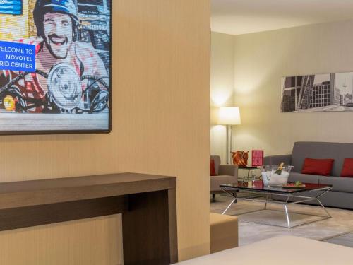 Habitación Executive con zona de salón y cama grande del hotel Novotel Madrid Center. Foto 16
