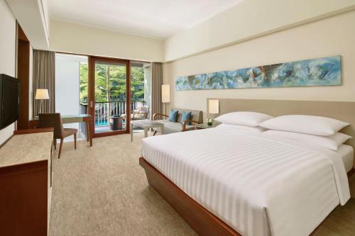 Habitación Deluxe con balcón y vistas a la piscina - Cama extragrande del hotel Courtyard By Marriott Bali Nusa Dua Resort. Foto 2