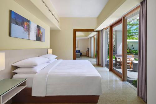 Suite de 1 dormitorio con balcón y vistas a la piscina - Cama extragrande del hotel Courtyard By Marriott Bali Nusa Dua Resort. Foto 1