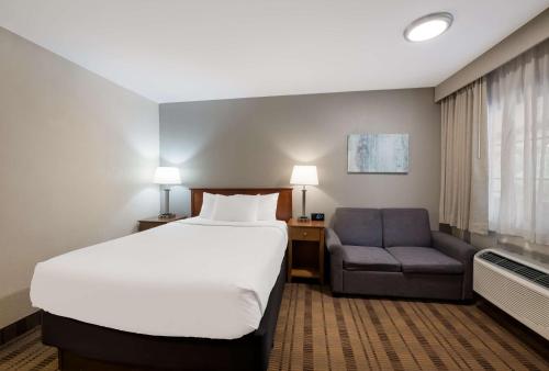 Habitación con cama grande y zona de cocina del hotel SureStay Plus by Best Western Woodbury Inn. Foto 2