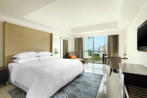 Guest Room Partial Ocean View, 1 King Bed (suitable for 2 adults & 2 children below 12 y.o. or 3 adults with Extra Bed) del hotel Sheraton Bali Kuta Resort - Chse Certified. Foto 1