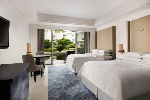 Guest Room Garden View, 2 Double Beds (suitable for 2 adults & 2 children below 12 y.o. or 3 adults with Extra Bed) del hotel Sheraton Bali Kuta Resort - Chse Certified. Foto 1